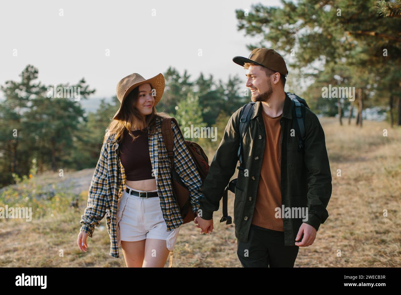 Primo piano, un giovane bacia una bella donna sullo sfondo di un falò di notte. Foto Stock