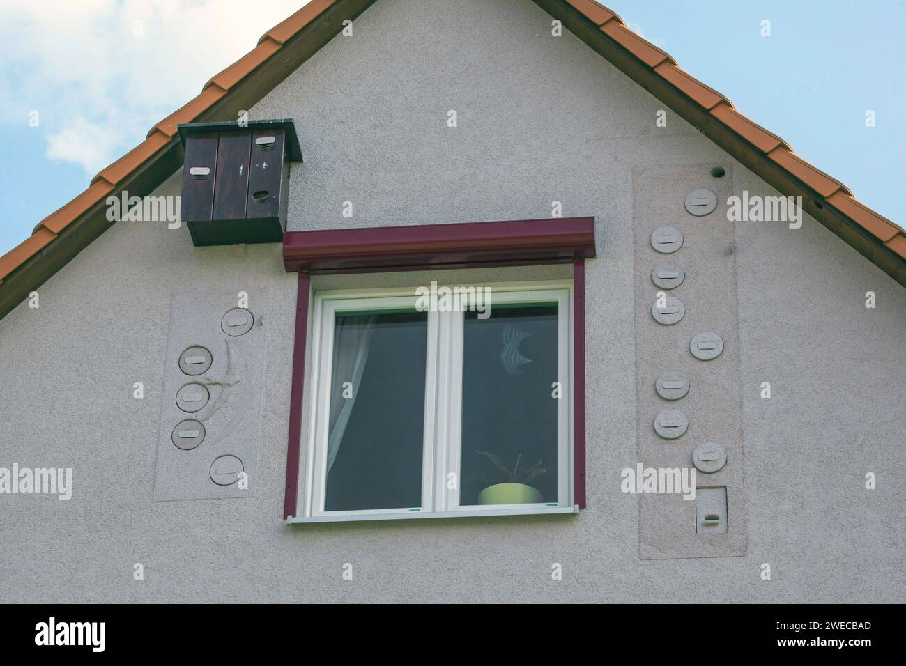 Coadiuvanti per la nidificazione di palloncini e pipistrelli sulla facciata di una casa sotto il tetto, Germania Foto Stock