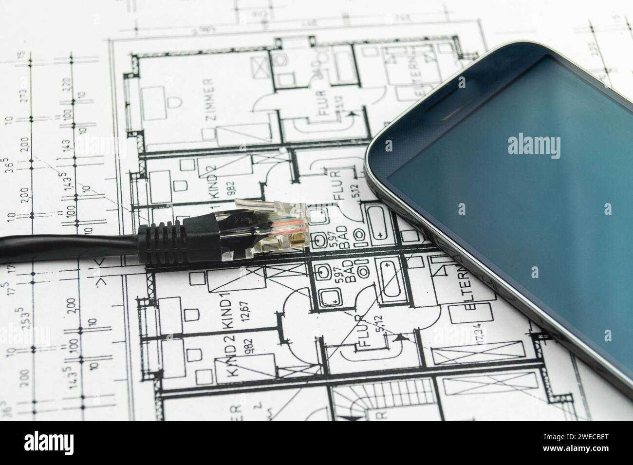 Spina di rete e smartphone sul disegno di costruzione, immagine simbolica per Smart Home Foto Stock