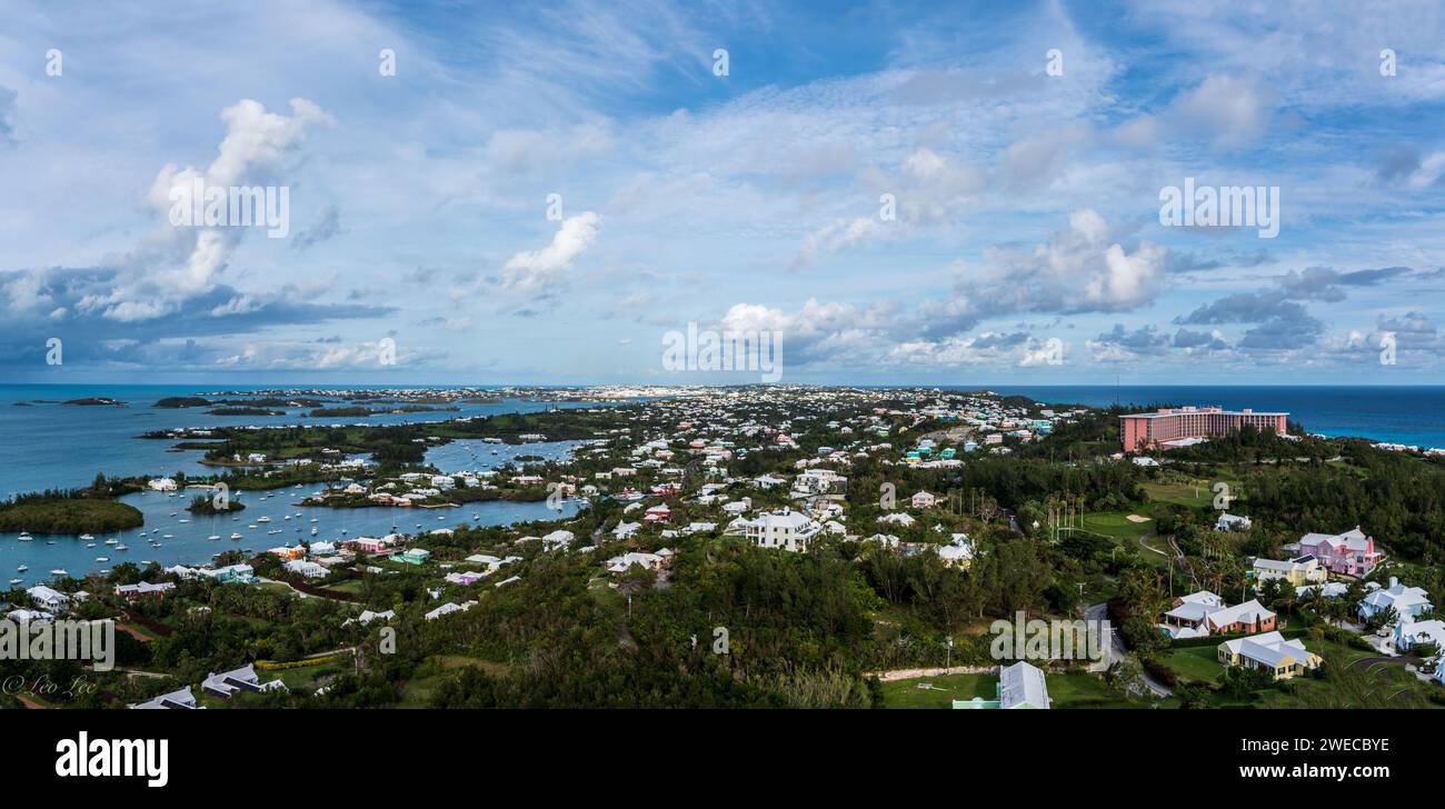 Sinfonia costiera delle Bermuda: Dove le acque azzurre incontrano i cieli vibranti, i paesaggi lussureggianti cullano le case affascinanti, creando un armonioso capolavoro dell'isola. Foto Stock