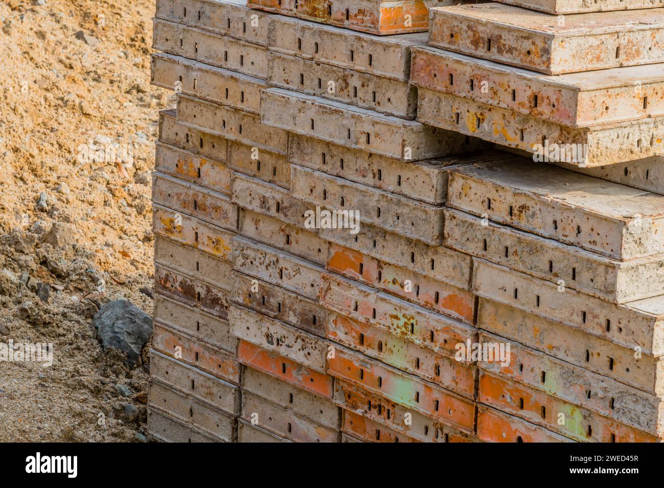 Primo piano di forme di calcestruzzo impilate sul terreno di un nuovo cantiere Foto Stock