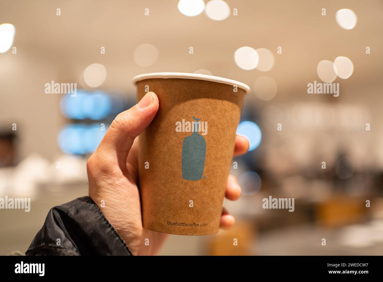 Tokyo, Giappone - 15 febbraio 2023: Tazza di caffè Blue Bottle in una mano. Foto Stock