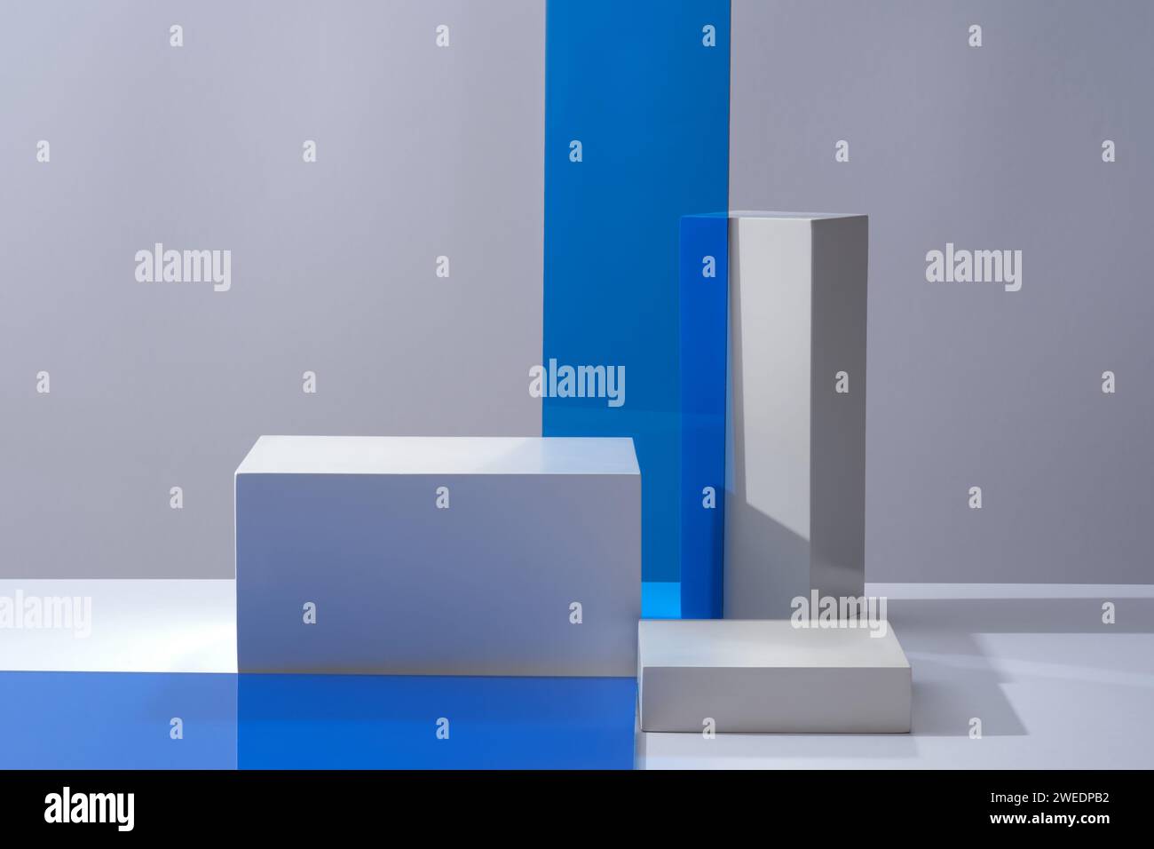 Scenografia minimalista di podi bianchi cilindrici e fogli acrilici blu decorati su uno sfondo chiaro. Spazio per il mockup di prodotti cosmetici. Prodotto e promozione Foto Stock