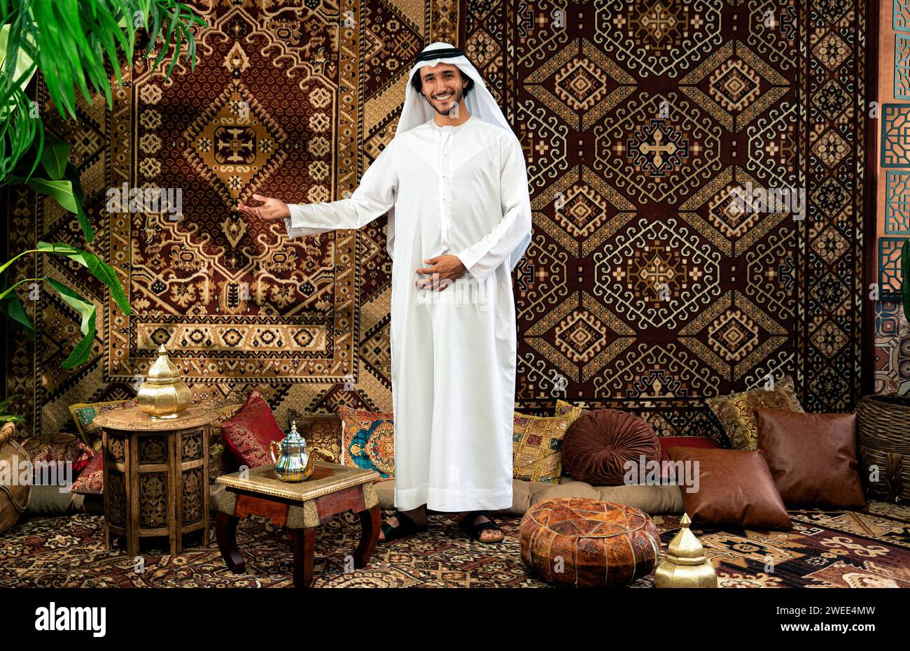 Uomo degli emirati che indossa un abito kandura trascorre del tempo in una casa tradizionale araba a Dubai Foto Stock