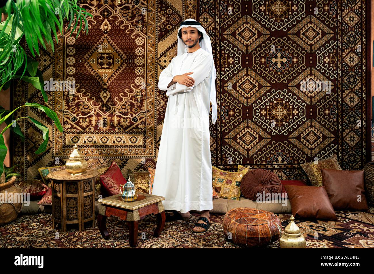 Uomo degli emirati che indossa un abito kandura trascorre del tempo in una casa tradizionale araba a Dubai Foto Stock