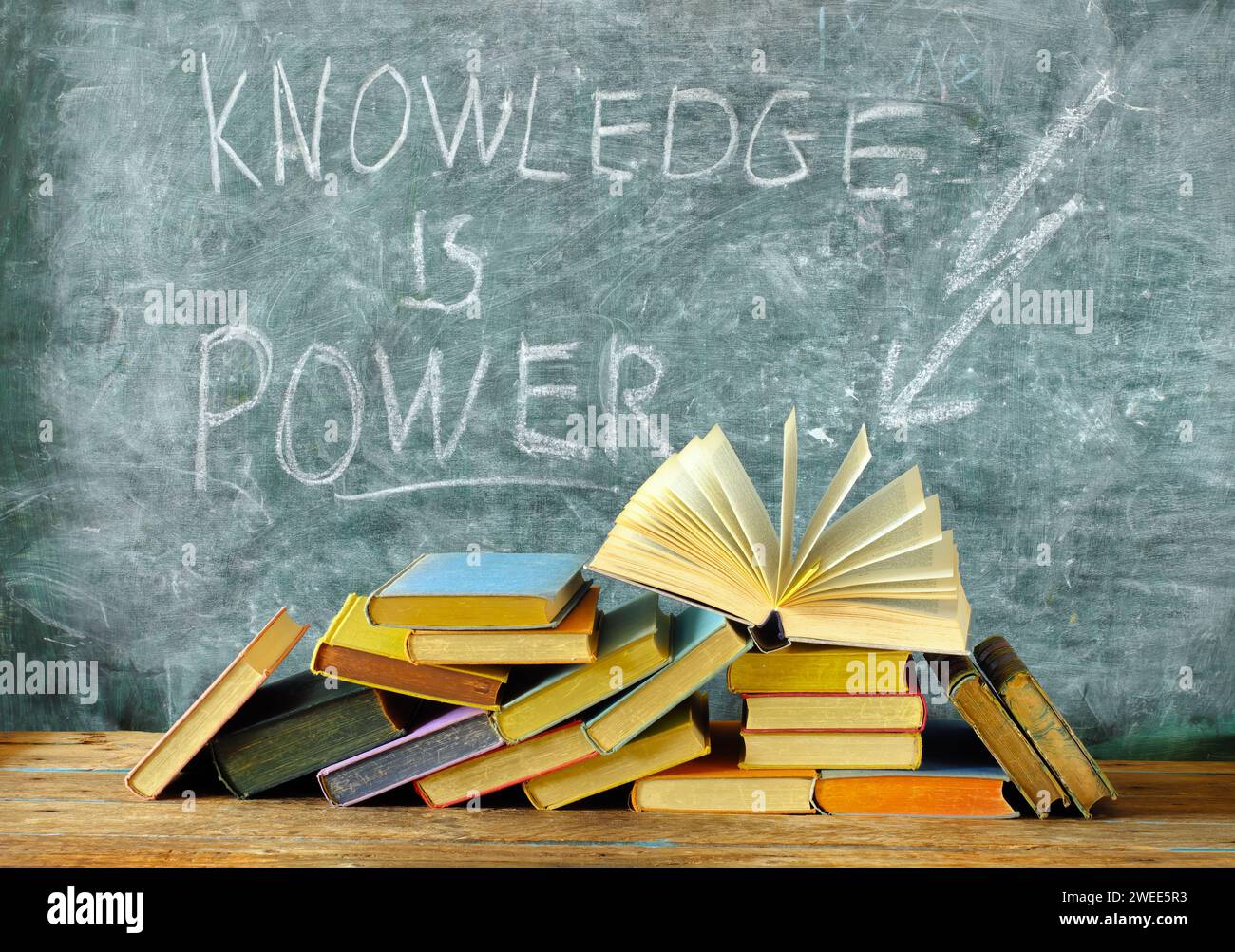 la conoscenza è potere, libri e lavagna con disegno di un simbolo di fulmine, istruzione, apprendimento, lettura, idea, concetto di ritorno a scuola. Foto Stock
