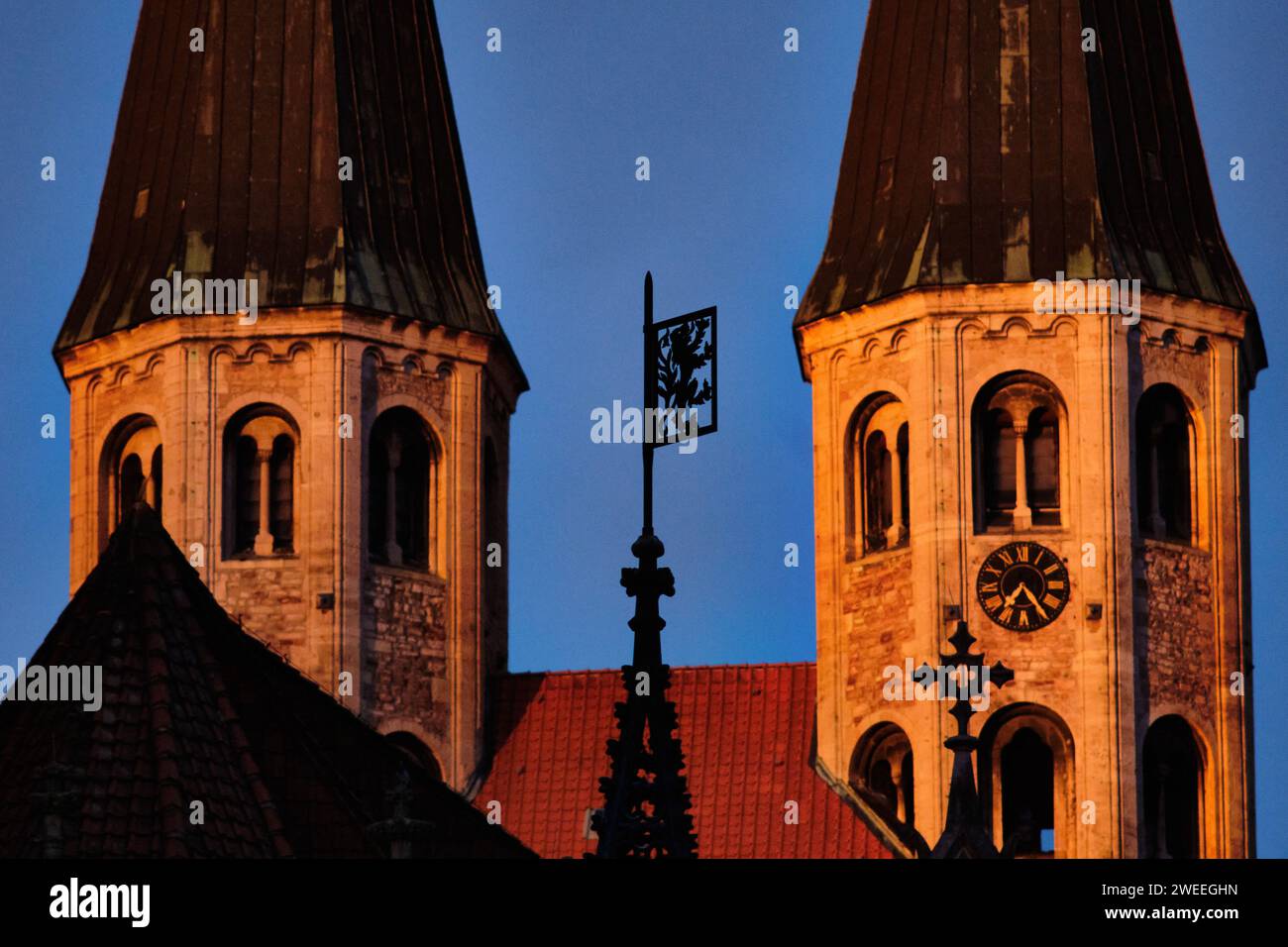 Brunswick, Germania. 2 novembre 2023. Le torri della Chiesa evangelica luterana La chiesa di Martin è illuminata dalla luce del sole che sorge; lo stemma della città, il "leone di Brunswick", può essere visto in primo piano sulla cima della fontana Marienbrunnen sull'Altstadtmarkt. Crediti: Stefan Jaitner/dpa/Alamy Live News Foto Stock