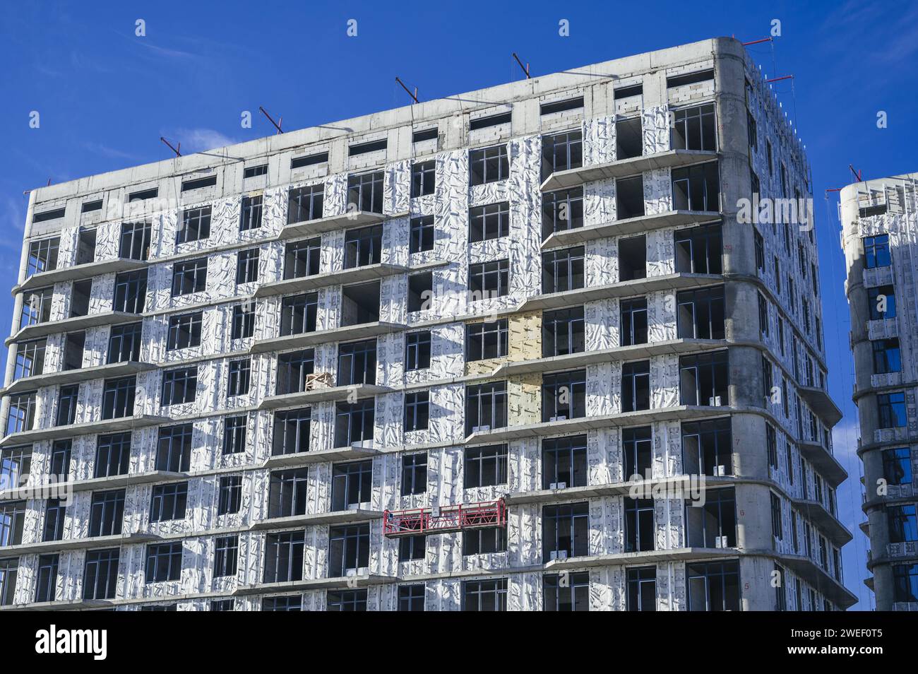 SHYMKENT, KAZAKHSAN - 3 GENNAIO 2024: Edificio residenziale in costruzione con pannelli di isolamento termico installati sulla facciata Foto Stock