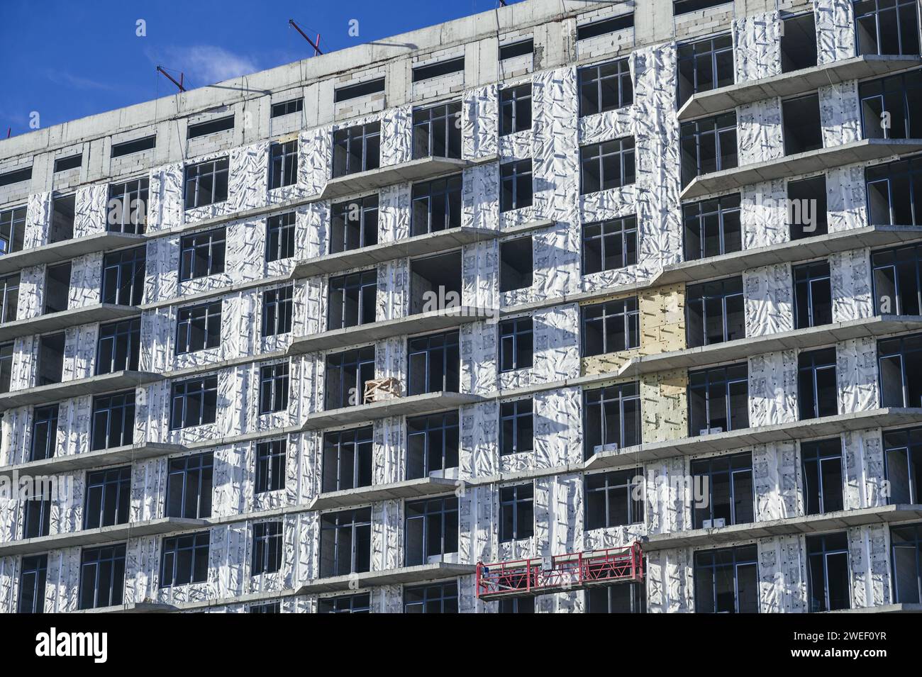 SHYMKENT, KAZAKHSAN - 3 GENNAIO 2024: Edificio residenziale in costruzione con pannelli di isolamento termico installati sulla facciata Foto Stock