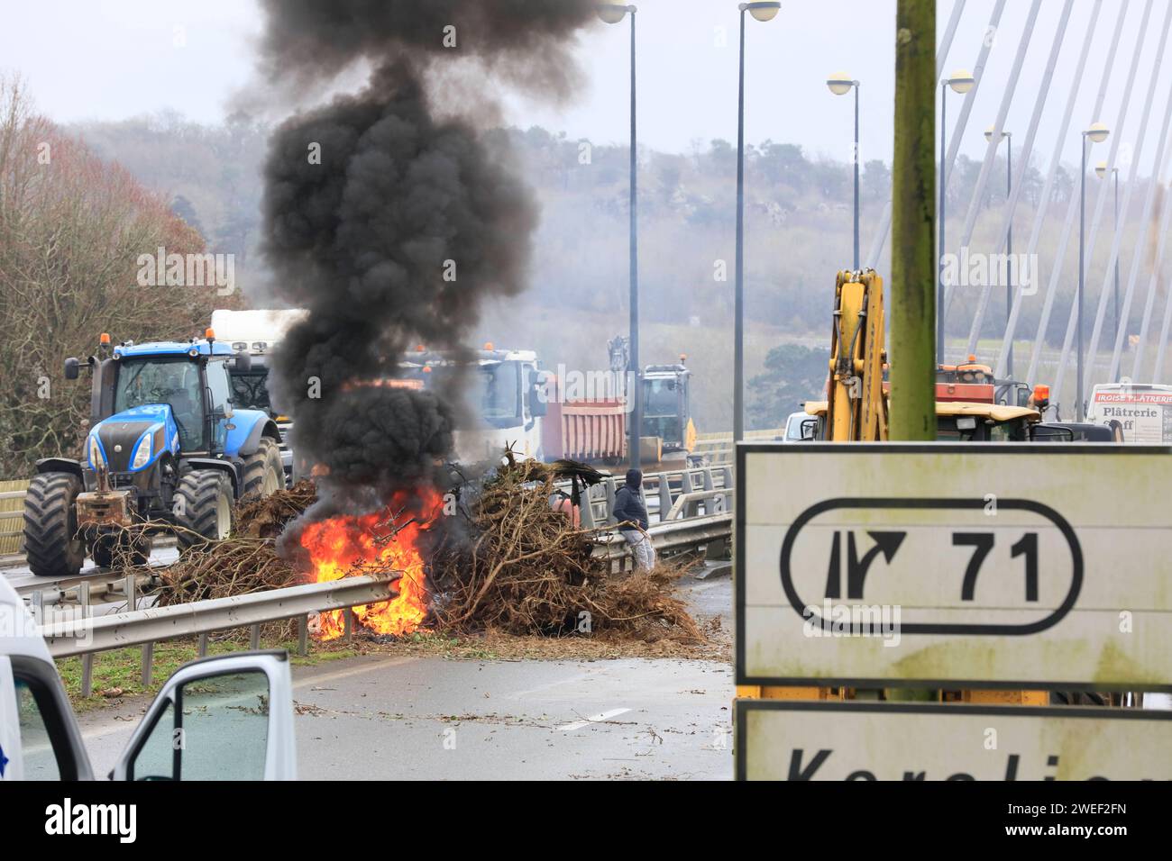 Bauern mit Traktoren, Handwerker mit Lieferwagen und LKW-Fahrer blockieren die gesperrte Brücke Pont de l iroise zwischen Brest und Plougastel-Daoulas und verbrennen Autoreifen, Protestaktion für bessere Bezahlung und Bürokratieabbau, Departement Finistere Penn-ar-Bed, regione Bretagne Breizh, Frankreich ** agricoltori con trattori ** artigiani con furgoni e camionisti bloccano il ponte chiuso Pont de l'iroise tra Brest e Plougastel Daoulas e bruciano pneumatici per auto, proteste per una migliore retribuzione e riduzione della burocrazia, dipartimento Finistere Penn ar Bed, regione Bretagne Breizh, Francia Foto Stock