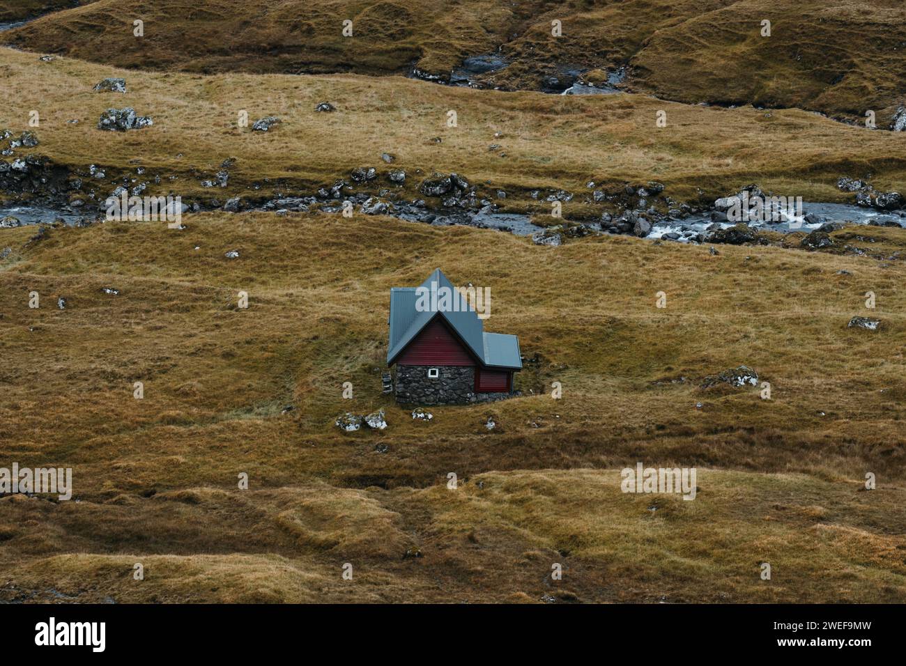 Casa isolata vicino al fiume nelle Isole Faroe Foto Stock
