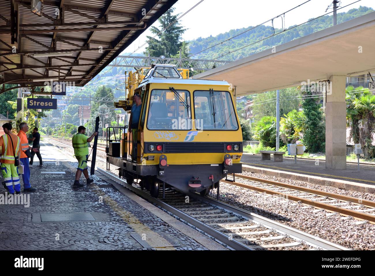 Un veicolo per la manutenzione dei binari Trenitalia si ferma alla stazione di Stresa per prelevare il personale. Foto Stock