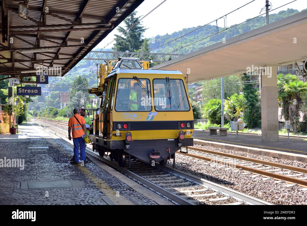Un veicolo per la manutenzione dei binari Trenitalia si ferma alla stazione di Stresa per prelevare il personale. Foto Stock