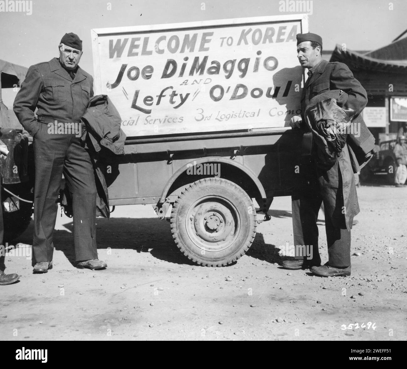 Joe DiMaggio (a destra), star dei New York Yankees e Lefty o'Doul, manager dei San Francisco Seals, arrivano a Kimpo AFB, e vengono accolti da un poster montato su una jeep che dice: "Welcome to Korea Joe DiMaggio and 'Lefty' o'Doul, Kimpo AFB, Corea, 11/10/1950. Foto di US Signal Corps/US Army Foto Stock