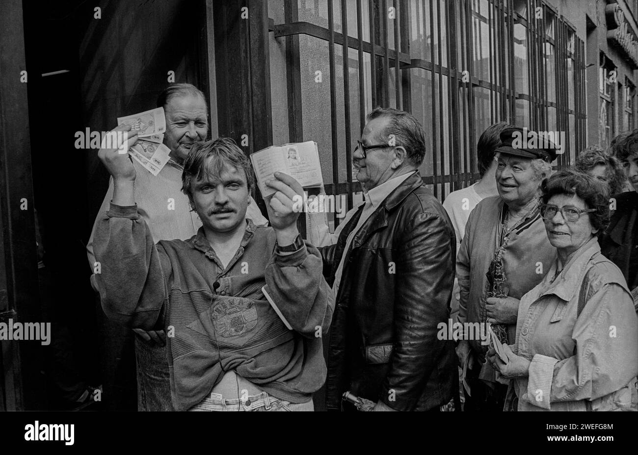 DDR, Berlino, 01.07.1990, Tag der Währungsunion, Sparkasse Rosenthaler Straße, Mann mit Westgeld und DDR Ausweis, Rolf Zoellner Währungsunion *** GDR, Berlino, 01 07 1990, Day of Monetary Union, Sparkasse Rosenthaler Straße, uomo con denaro della Germania Ovest e ID della DDR, Unione monetaria Rolf Zoellner Foto Stock