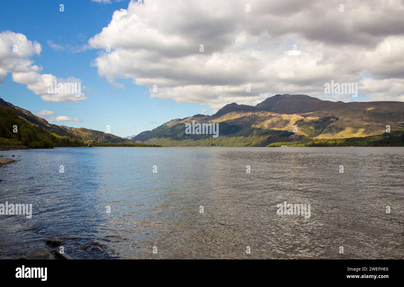 Vista sul Loch Lommond, con l'aspra vetta del Ben Lommond all'ombra, che si innalza sullo sfondo, nelle Highlands scozzesi Foto Stock