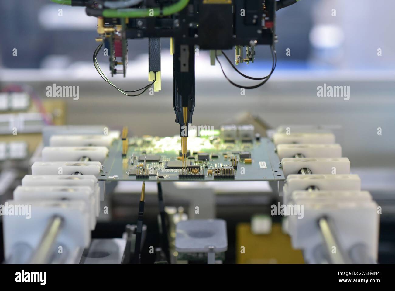 Robot assembla automaticamente la scheda a circuito stampato con componenti elettronici in un moderno stabilimento Foto Stock