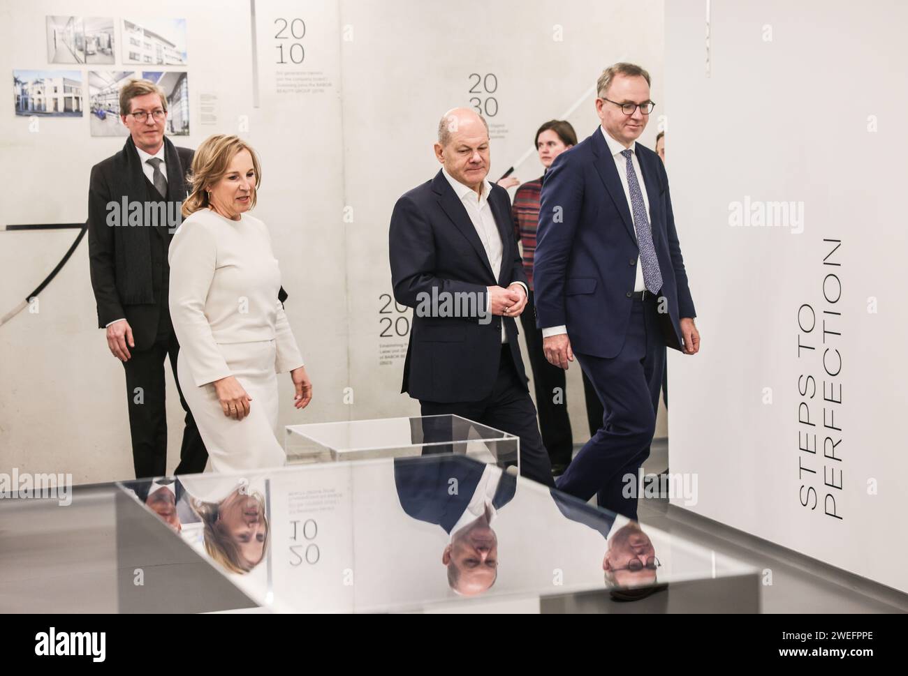 Eschweiler, Germania. 25 gennaio 2024. Il Cancelliere federale Olaf Scholz (2° da sinistra, SPD) cammina attraverso il nuovo stabilimento di produzione vicino a Eschweiler con i proprietari della Barbor Beauty Company, Martin Grablowitz (r) e Isabel Bonacker (2° da sinistra). Crediti: Oliver Berg/dpa/Alamy Live News Foto Stock