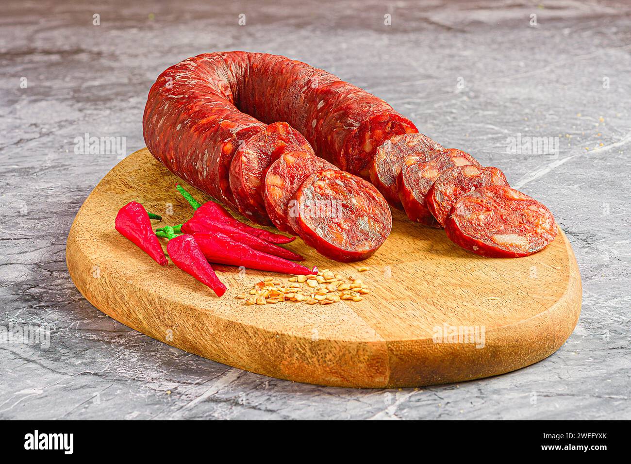 Un primo piano di Chorizo a fette accompagnato da peperoncino Foto Stock