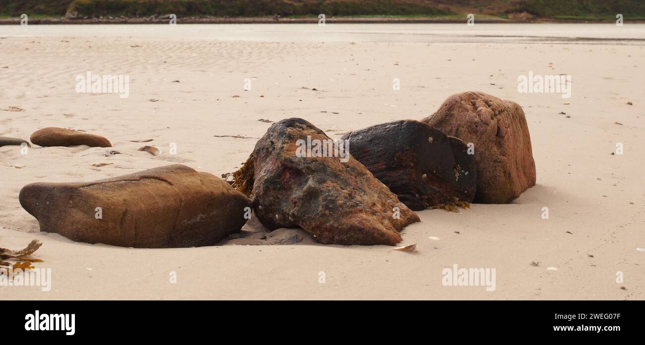 Grandi rocce sulla spiaggia sabbiosa di Waulkmill Bay, Orcadi, Scozia, Regno Unito con la bassa marea Foto Stock