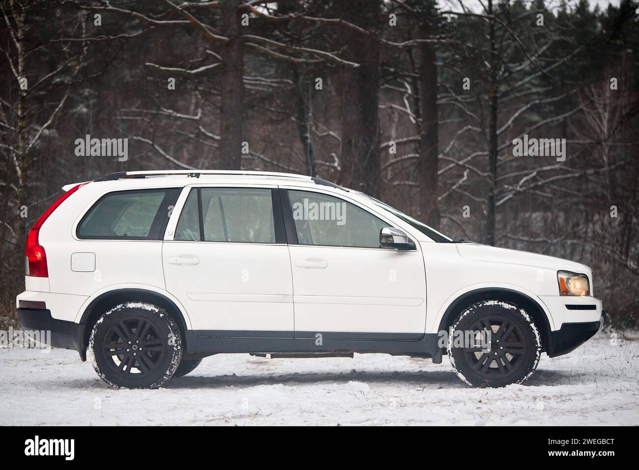 Berlino, Germania - 4 dicembre 2023: Volvo XC90 4,4 v8 prova su strada di campagna invernale su fondo forestale a destra Foto Stock