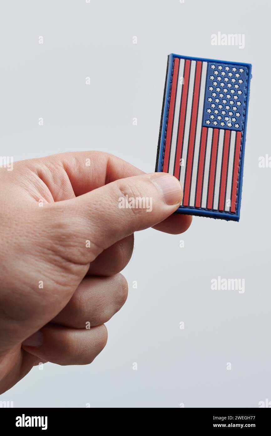 Vista ravvicinata dell'adesivo con bandiera americana con mano isolata su sfondo bianco dello studio Foto Stock