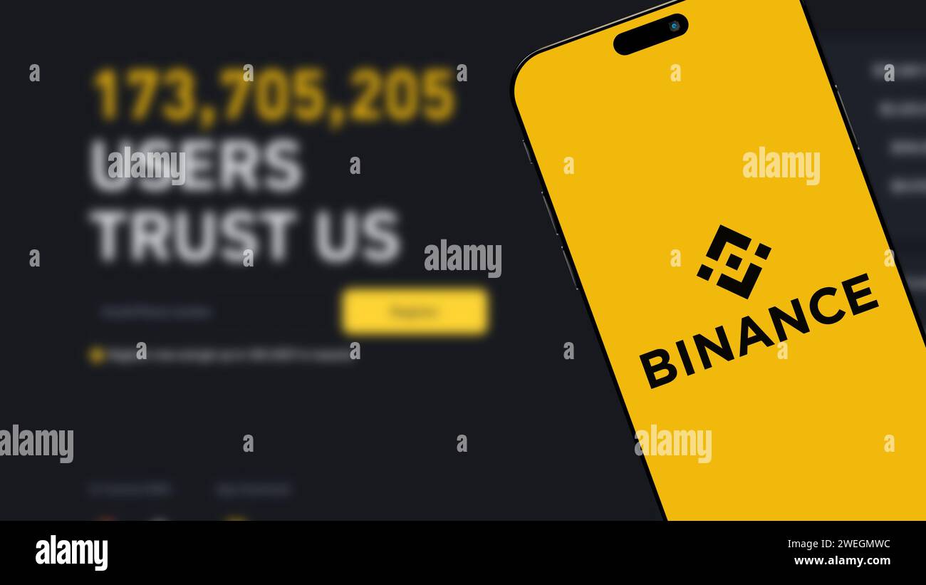 Istanbul, Turchia - 25 gennaio 2024: Logo del marchio Binance sullo schermo dello smartphone con il sito Web Binance sullo sfondo. Binance è una criptovaluta globale ecc Foto Stock