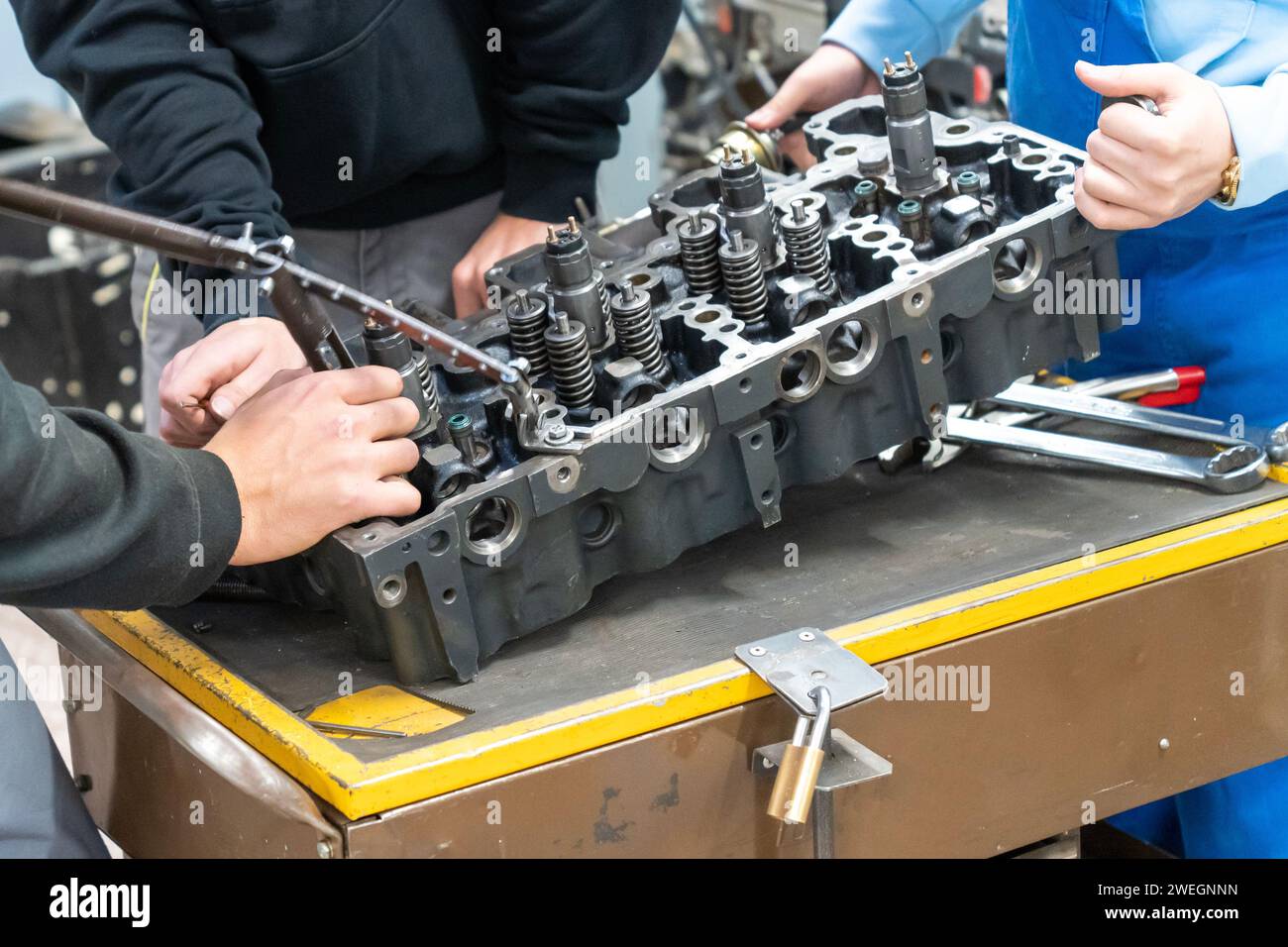 Meccanici automatici che montano un motore per auto smontato in officina Foto Stock