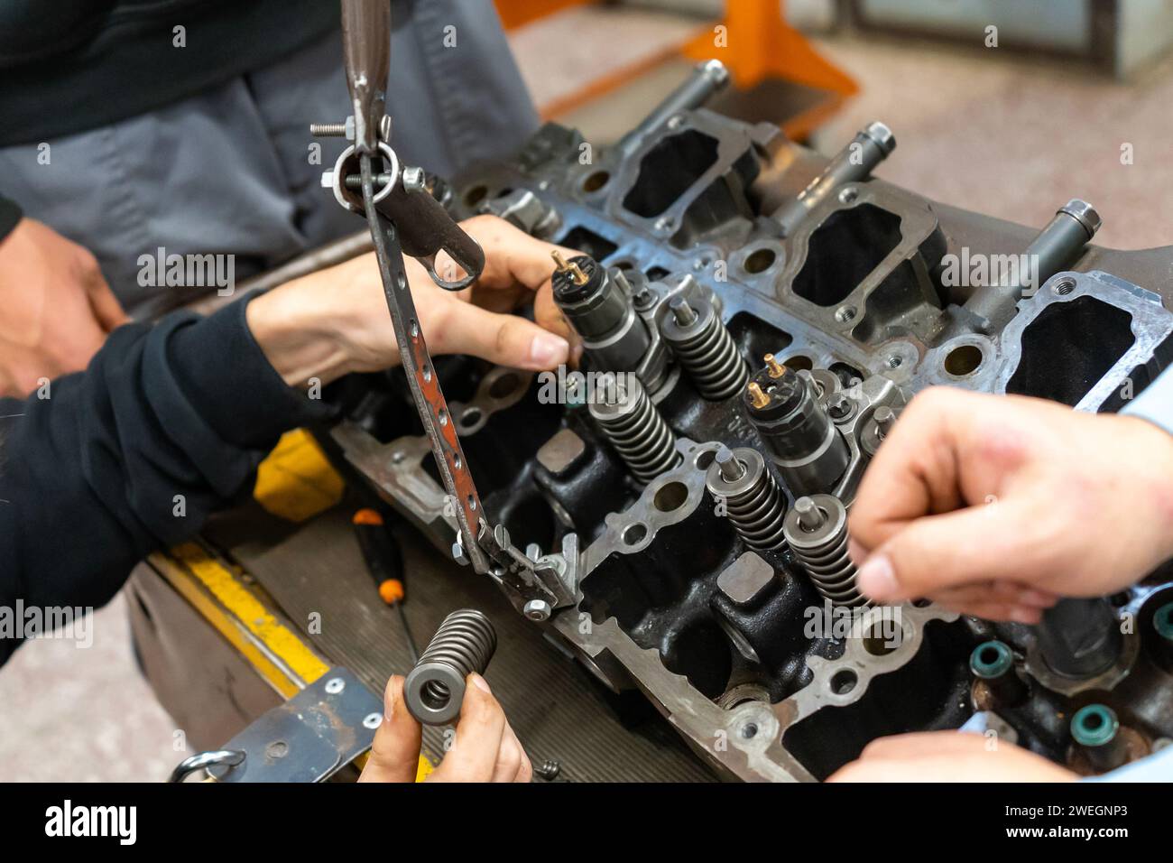Meccanici automatici che montano un motore per auto smontato in officina Foto Stock