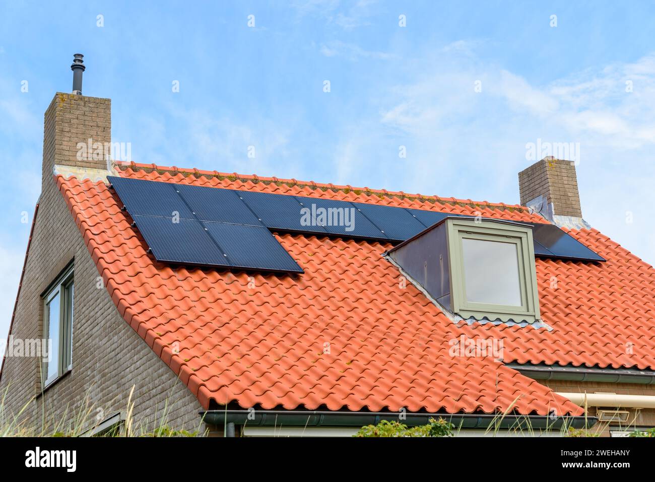 Pannelli solari sul tetto di una casa a risparmio energetico Foto Stock