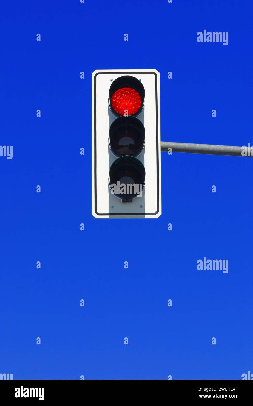 Semafori in Germania, in rosso, contro un cielo blu Foto Stock