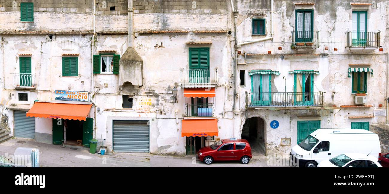 Vecchia facciata fatiscente di un edificio residenziale con balconi e un concessionario di auto usate a minori, Costiera Amalfitana, Italia, Europa Foto Stock