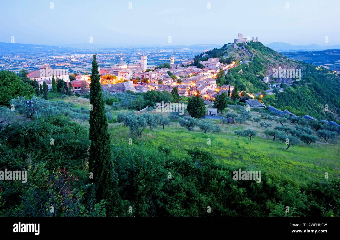 Ammira Assisi la mattina presto, ora blu, con il castello di Rocca maggiore su una collina accanto alla città, Assisi, Umbria, Italia, Europa Foto Stock