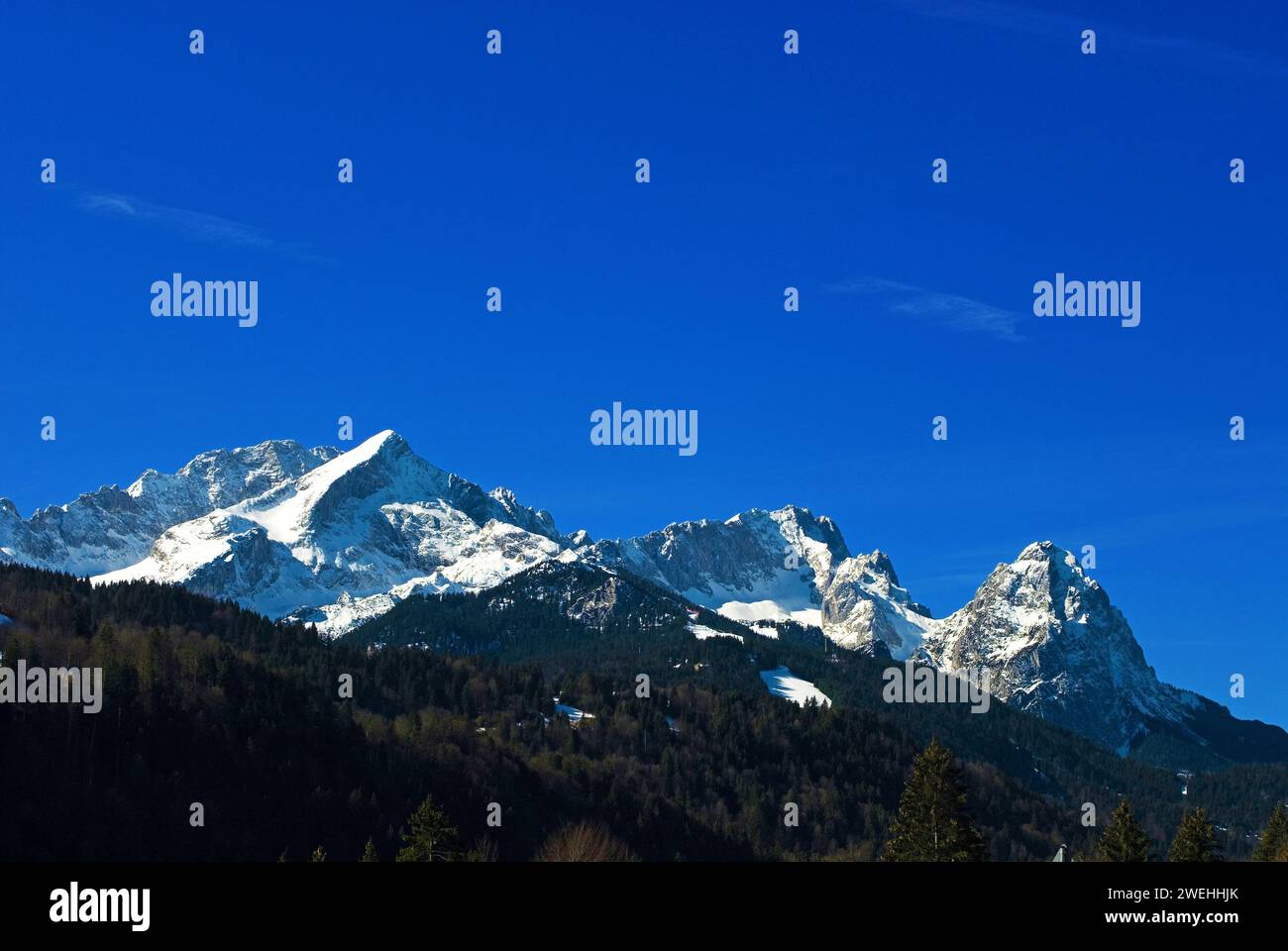 Panorama montano della catena montuosa del Wetterstein in primavera, con Alpspitze sulla sinistra, Zugspitze al centro e Waxenstein sulla destra Foto Stock