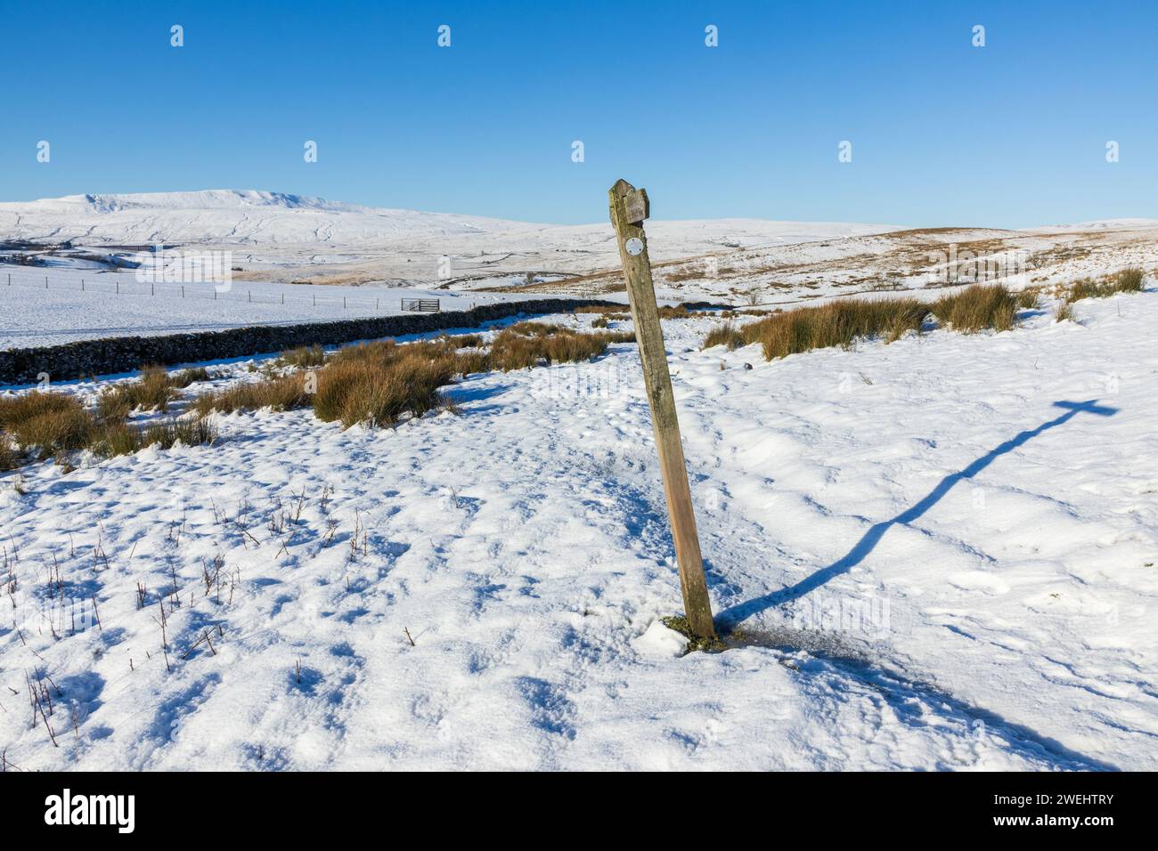 Un cartello per le Yorkshire Dales in Inghilterra in una splendida giornata invernale con molta neve a terra e cielo azzurro. Preso sui tre picchi. Foto Stock