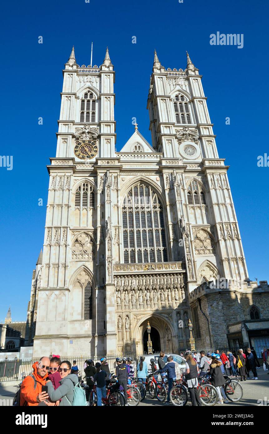 I turisti visitano l'ingresso della Great West Door sotto i campanili della facciata occidentale dell'Abbazia di Westminster nel centro di Londra, Inghilterra, Regno Unito Foto Stock
