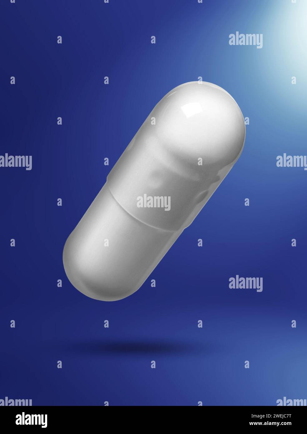 Capsula vitaminica in aria su sfondo blu gradiente Foto Stock