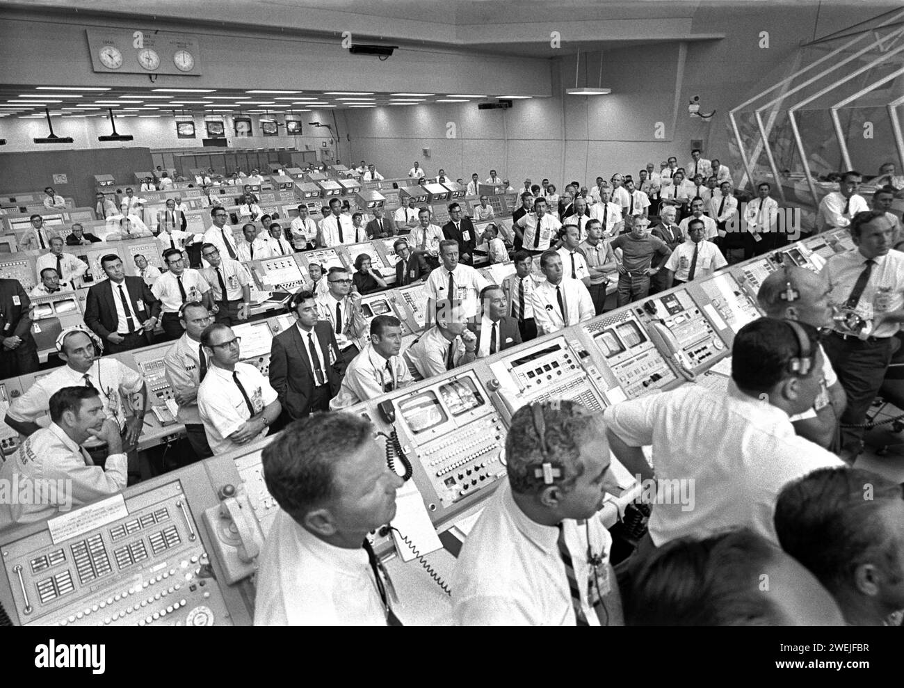 I membri del team governativo si alzano dalle loro console nel Launch Control Center per ascoltare le osservazioni del Vice Presidente degli Stati Uniti Spiro Agnew dopo il decollo dell'Apollo 11, Kennedy Space Center, Merritt Island, Florida, USA, NASA, 16 luglio 1969 Foto Stock