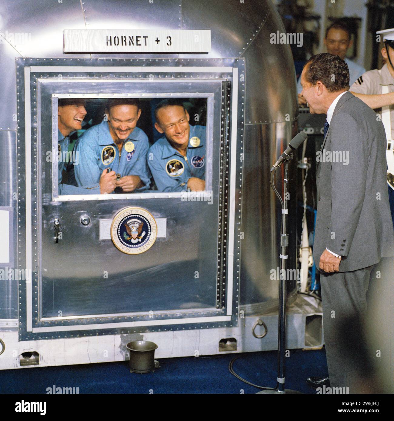 Il presidente degli Stati Uniti Richard Nixon saluta gli astronauti dell'Apollo 11 Neil A. Armstrong, Edwin E. Aldrin e Michael Collins, all'interno della struttura di quarantena dopo il successo della missione di recupero, USS Hornet, NASA, 24 luglio 1969 Foto Stock
