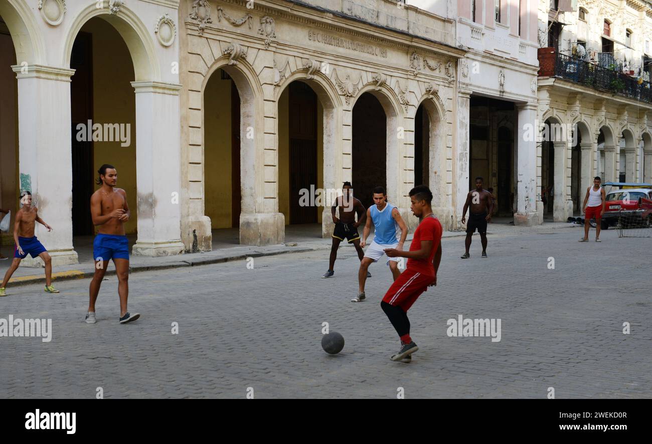 Uomini cubani che giocano a calcio nelle strade della vecchia Havana, Cuba. Foto Stock