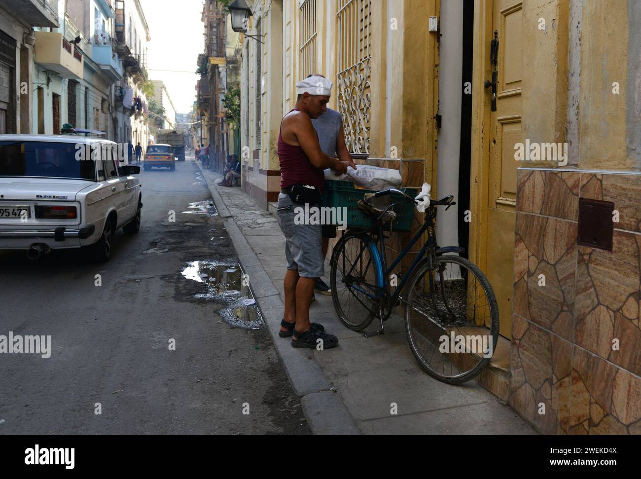 Un uomo che consegna il pane sulla sua bicicletta a l'Avana vecchia, Cuba. Foto Stock