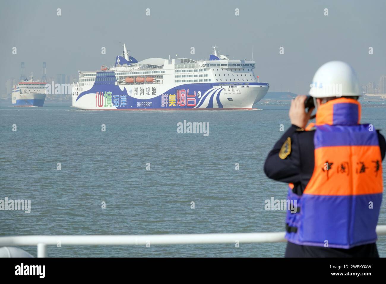 YANTAI, CINA - 26 GENNAIO 2024 - Un ufficiale delle forze dell'ordine marittime ispeziona le navi passeggeri marittime nelle acque al largo di Yantai, Shandon della Cina orientale Foto Stock