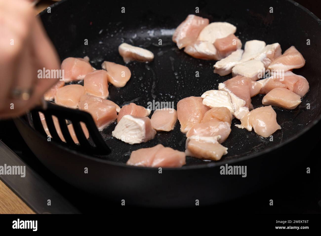 Baviera, Germania - 25 gennaio 2024: Strisce di pollo fritte in padella con olio caldo *** Hähnchenfleisch Streifen werden in einer Pfanne mit heißem Öl angebraten Foto Stock