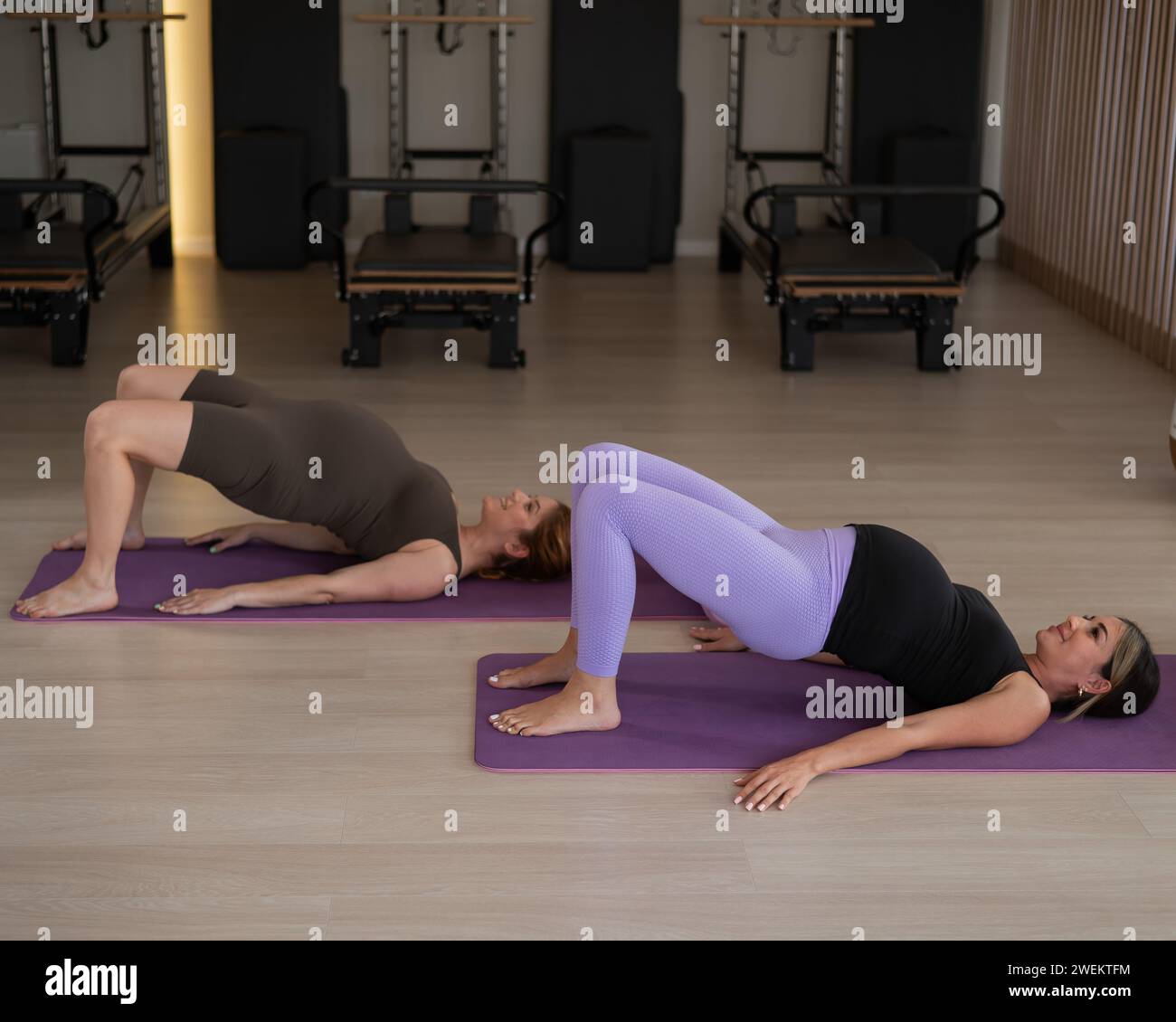 Due donne incinte fanno esercizi di rafforzamento del pavimento pelvico. Ponte gluteale. Foto Stock