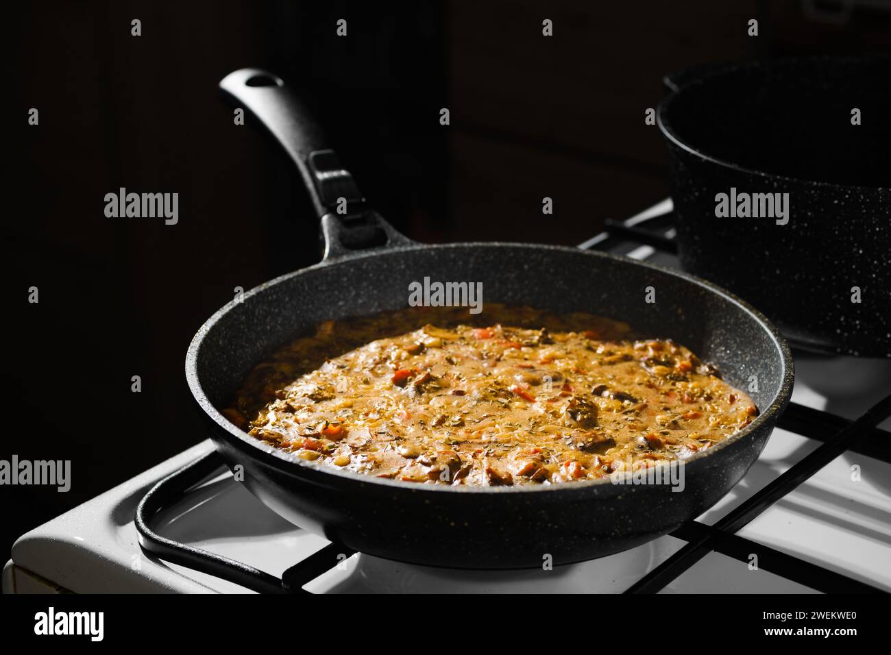 La torta di funghi caldi con carne di pollo estratta dal forno si raffredda sulla stufa a gas Foto Stock