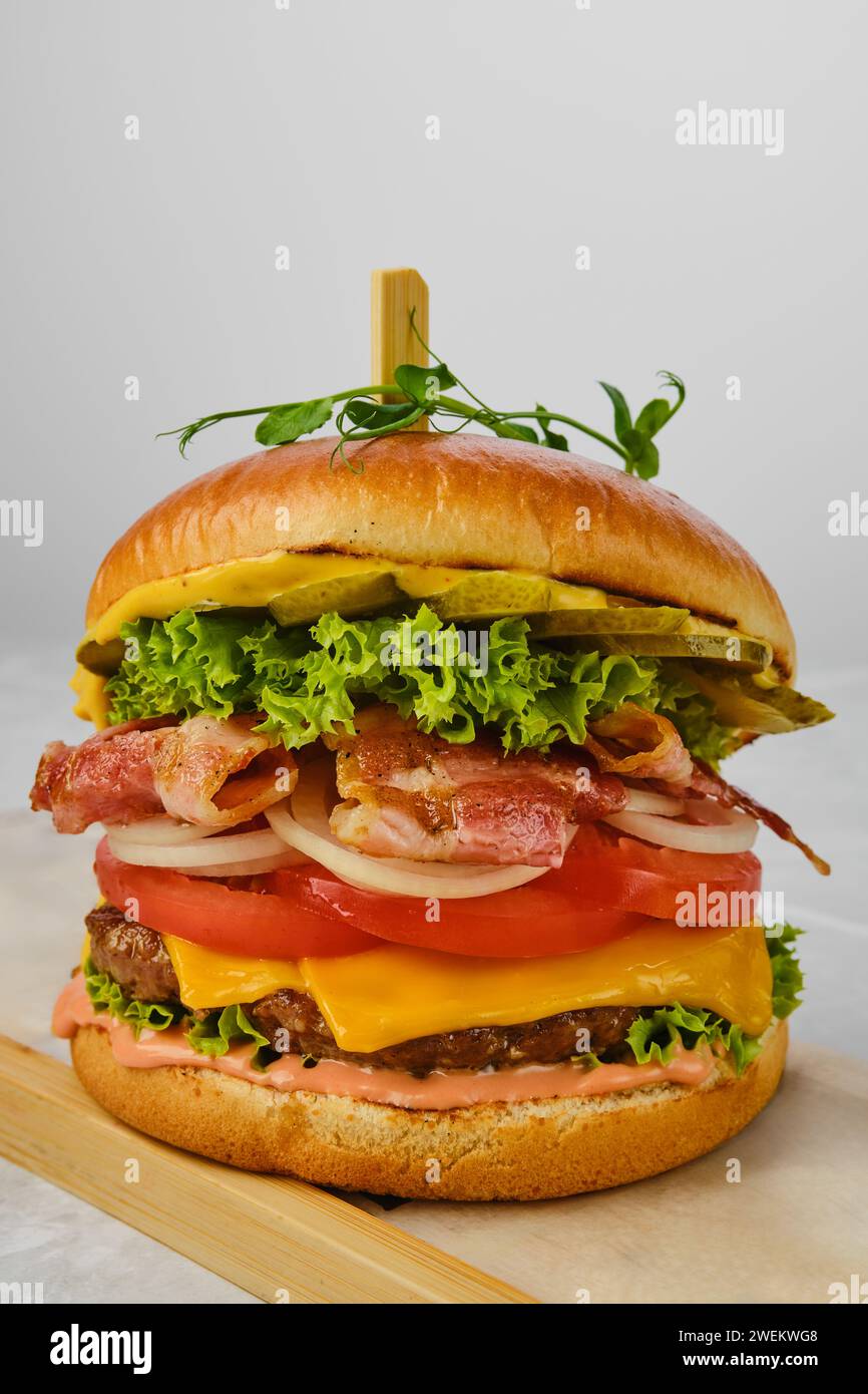 Vista ravvicinata dell'hamburger di manzo con pancetta, formaggio e verdure Foto Stock