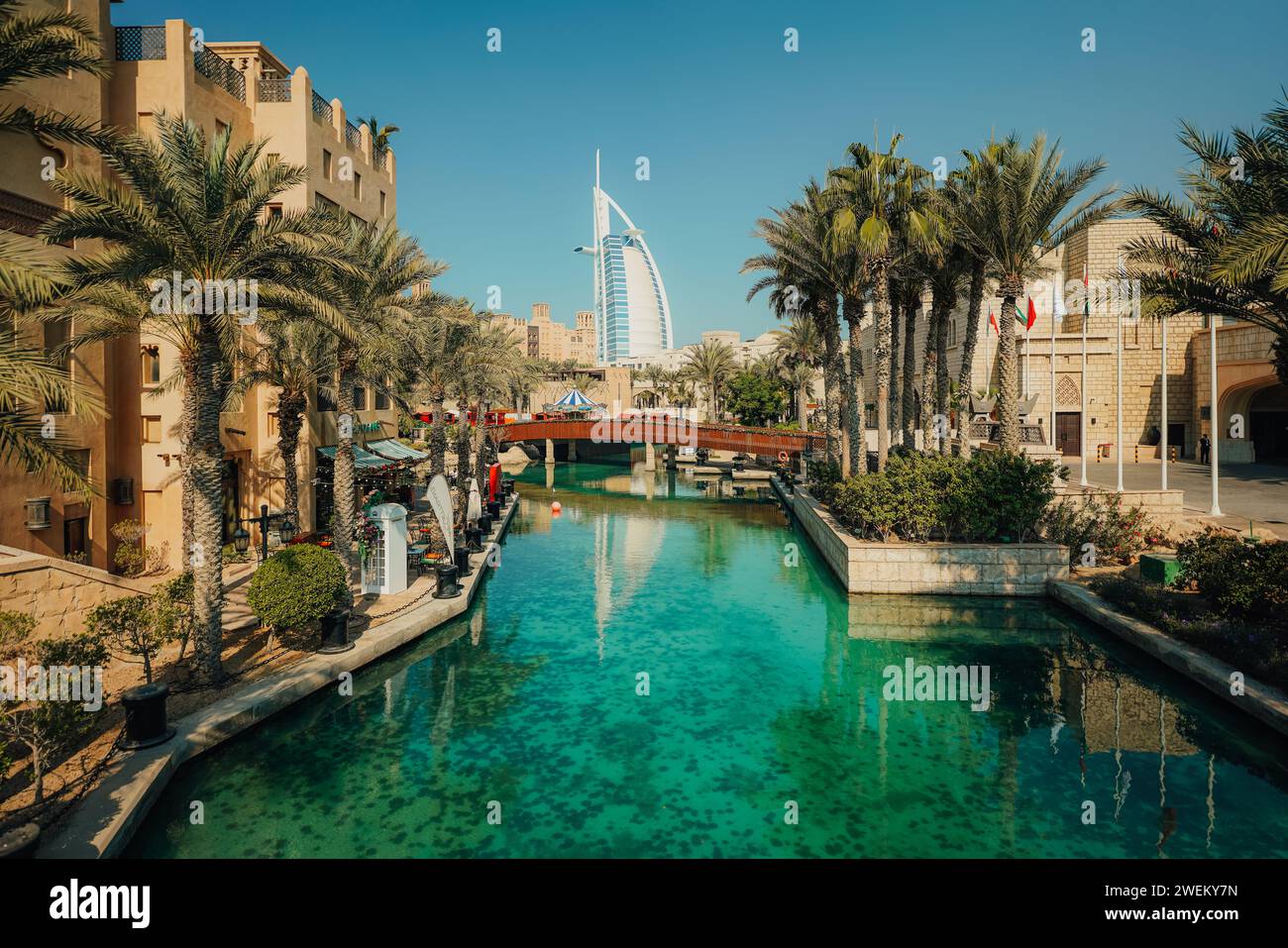 Una vista panoramica delle palme e della vegetazione lussureggiante confinano con un tranquillo canale navigabile a Dubai, Emirati Arabi Uniti Foto Stock