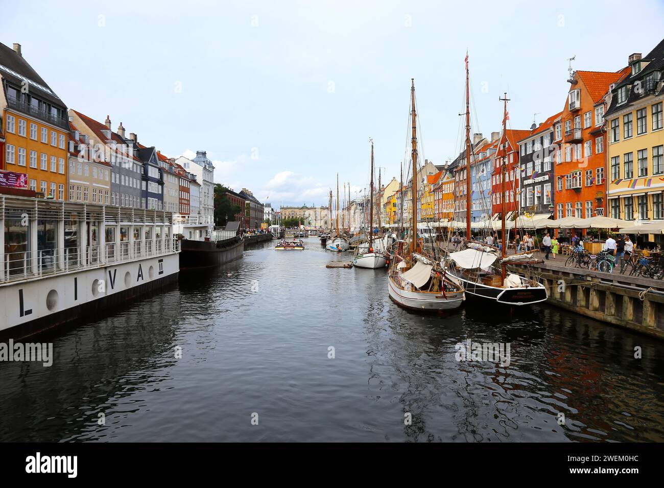 Copenaghen, Danimarca - 17 agosto 2023: Il canale di Nyhavn. I turisti navigano in barca a bordo del fiume Nyhavn con bar e ristoranti a buildi Foto Stock