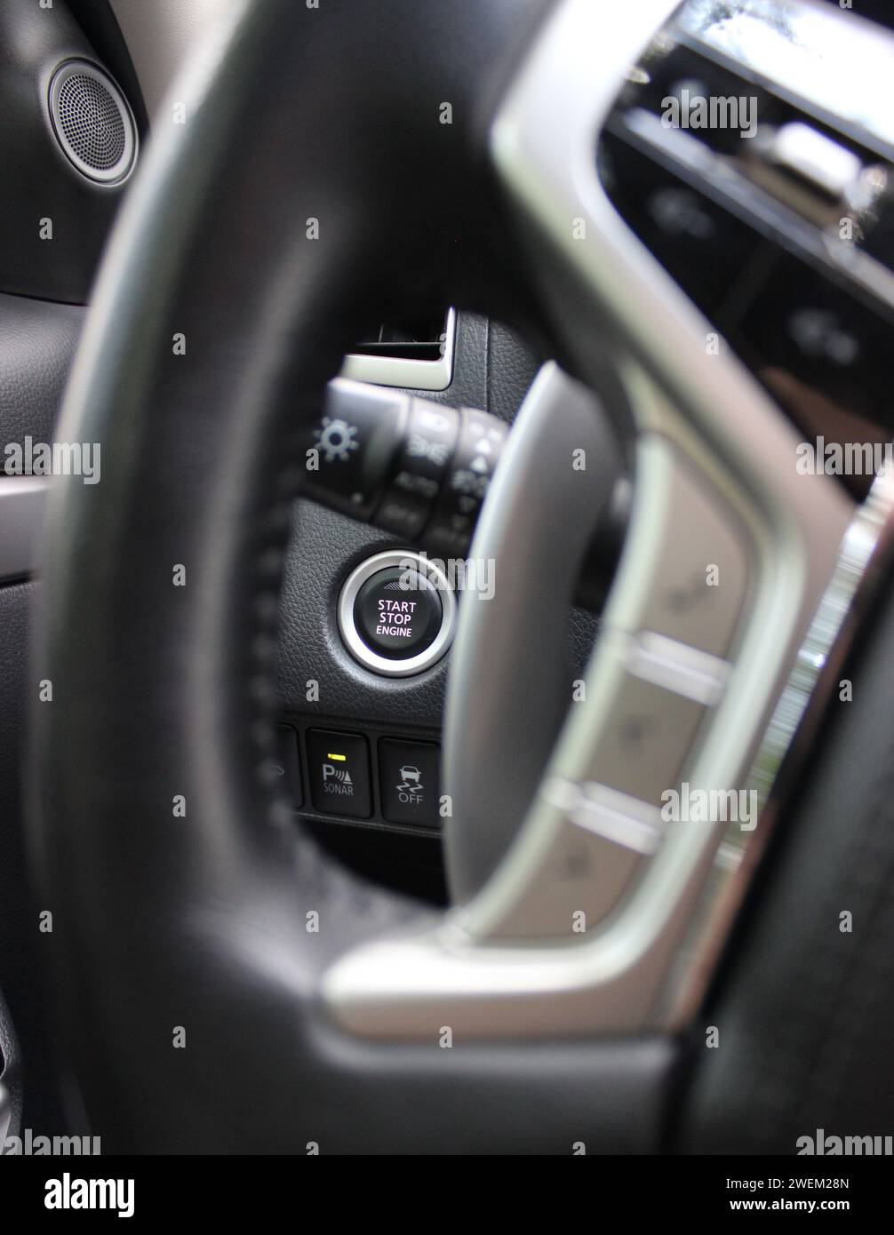Pulsante di avviamento del motore, pulsante di controllo attivo dei sensori di parcheggio e sistema di controllo della stabilità sotto il volante all'interno Di Una vettura Foto Stock