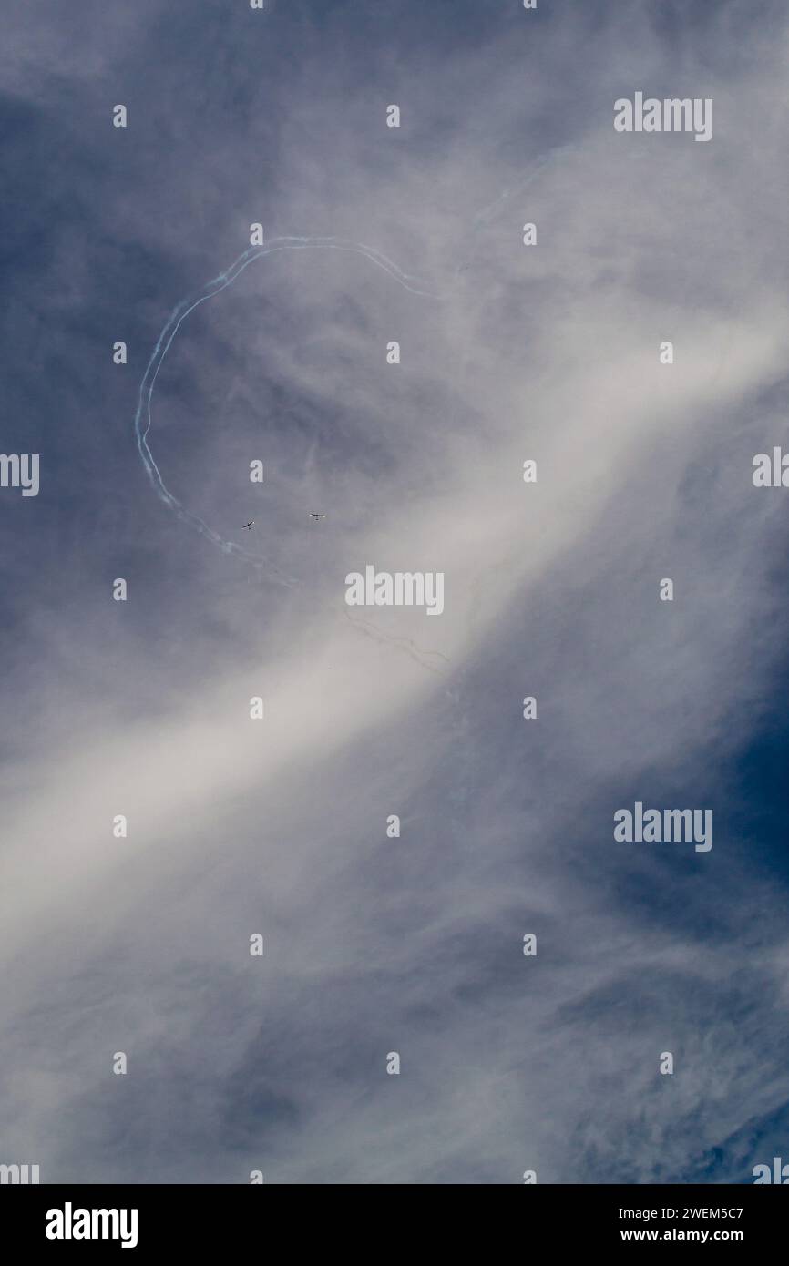 due piani disegnano un cuore sul cielo blu sullo sfondo di nuvole bianche Foto Stock